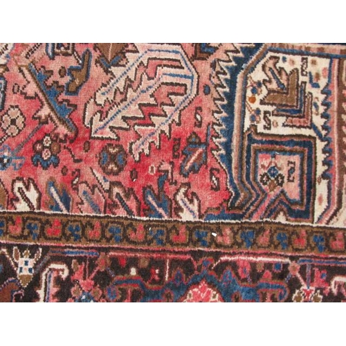 485 - Large red and cream ground patterned rug having a large central geometric motif surrounded by three ... 