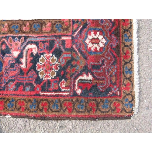 485 - Large red and cream ground patterned rug having a large central geometric motif surrounded by three ... 