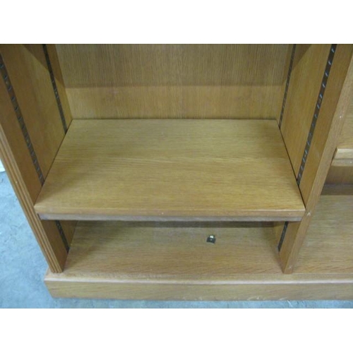 494 - Oak open bookshelves having two divisions and four adjustable shelves, standing on a plinth base - 1... 