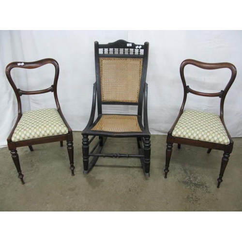 500 - Ebonised rocking chair having a cane panel back and seat, standing on stretchered turned legs with r... 