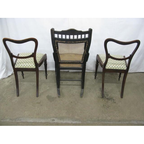 500 - Ebonised rocking chair having a cane panel back and seat, standing on stretchered turned legs with r... 