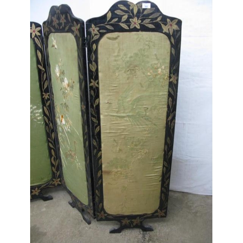 502 - Four fold screen having black and gilt foliate painted frames with padded inset panels with needlepo... 