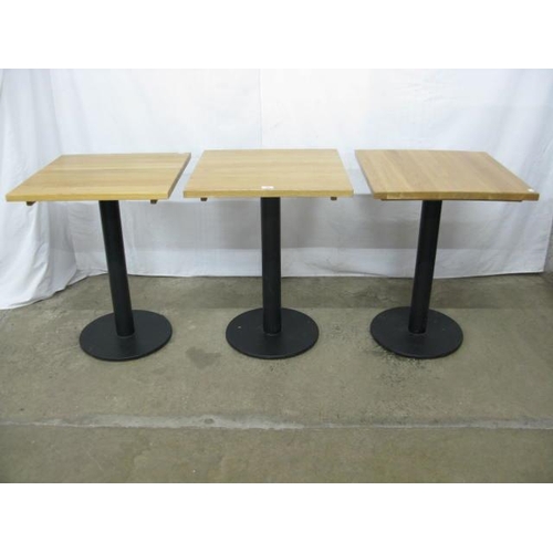 505 - Set of three Warings Furniture bistro tables, the square oak tops standing on round metal columns wi... 