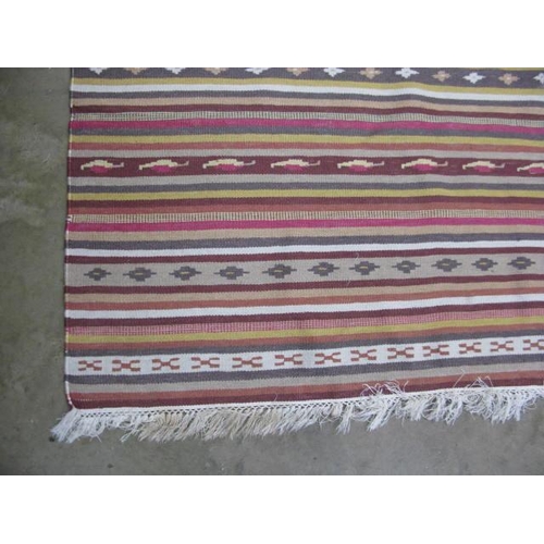 506 - Stripey patterned rug with geometric repeating motifs and end tassels - 2.98m x 2m