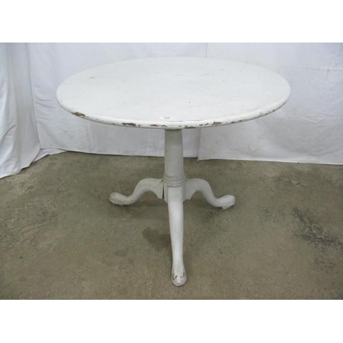 520 - White painted tilt top table, the circular top over a bird cage movement with a turned column suppor... 