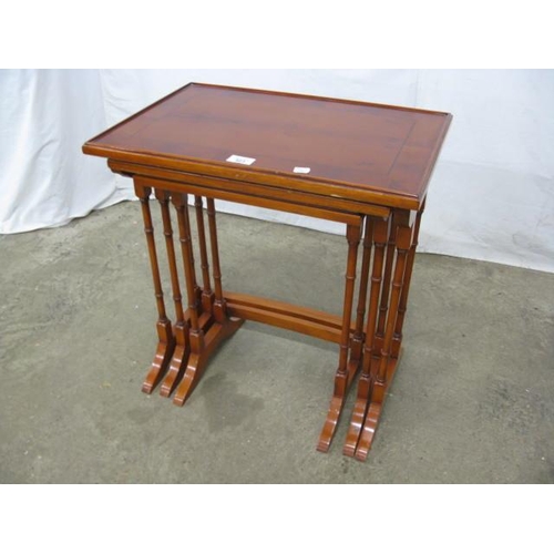 523 - Inlaid cross banded yew wood nest of three tables, the rectangular tops standing on turned supports ... 