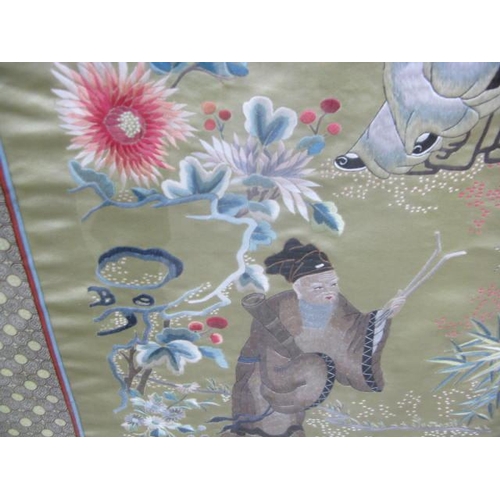 534 - Three Oriental embroidered silks all having a central panel decorated with figures, trees, flowers a... 