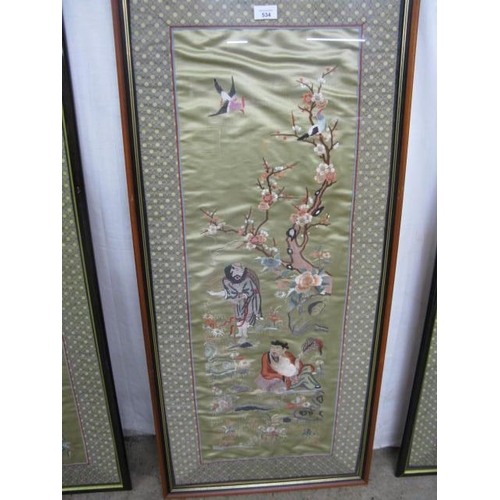 534 - Three Oriental embroidered silks all having a central panel decorated with figures, trees, flowers a... 