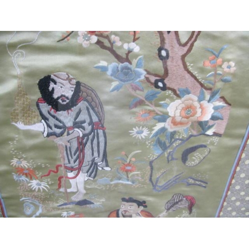 534 - Three Oriental embroidered silks all having a central panel decorated with figures, trees, flowers a... 