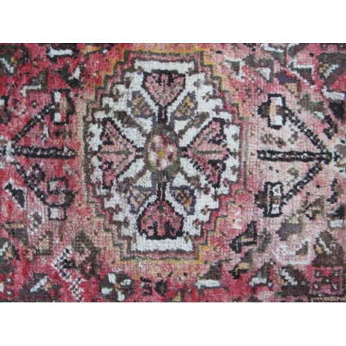 536 - Red ground patterned rug having five central motifs surrounded by geometric shapes and patterned bor... 