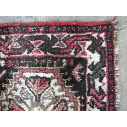 536 - Red ground patterned rug having five central motifs surrounded by geometric shapes and patterned bor... 