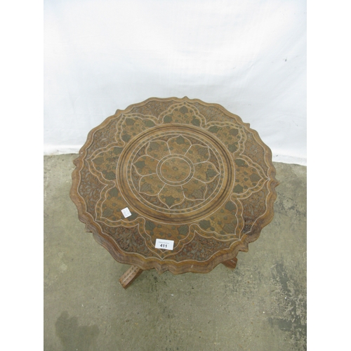 411 - Carved hardwood table having a shaped top with foliate brass inlay, standing on a turned column with... 