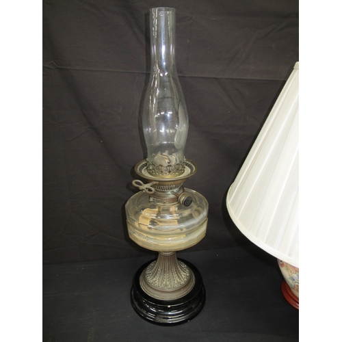68 - Two oil lamps together with a table lamp