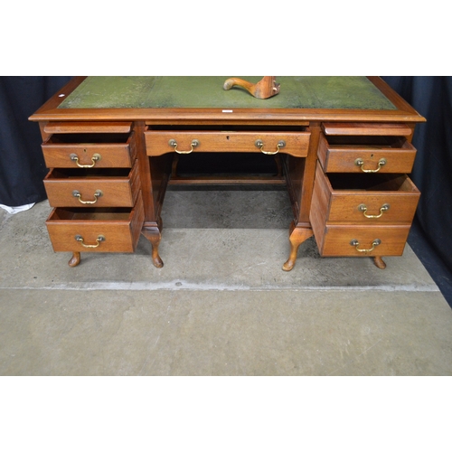 254 - Mahogany kneehole desk having green leather insert over a series of slides and drawers with brass ha... 