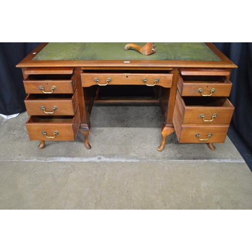 254 - Mahogany kneehole desk having green leather insert over a series of slides and drawers with brass ha... 