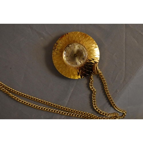 45 - A vintage Tegrov gold tone pendant antimagnetic watch and chain. Impressed floral design to the back... 