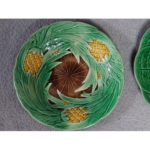 14 - Four antique majolica plates. One designed by George Jones of pineapples in a basket, the waterlilly... 