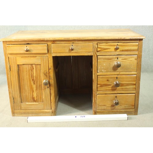 484 - A Victorian pitch pine kneehole desk, with three short drawers, over a cupboard door to one pedestal... 