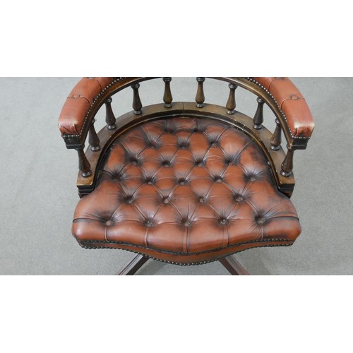 10 - A Victorian style captain's swivel desk chair, with a brown leather buttoned back and seat, and a sp... 