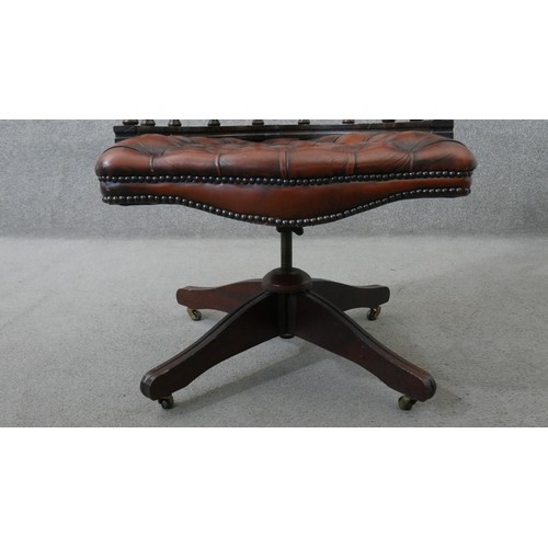 10 - A Victorian style captain's swivel desk chair, with a brown leather buttoned back and seat, and a sp... 