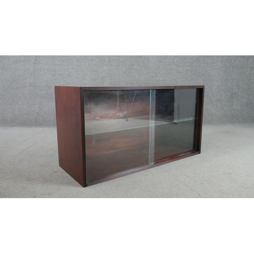 298 - A circa 1970s fruitwood side cabinet, of rectangular form with two glass sliding doors, enclosing an... 