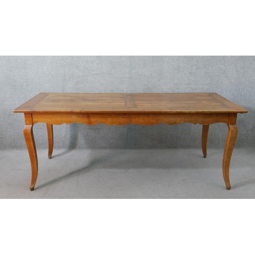 11 - A 19th century French cherrywood farmhouse dining table, the rectangular cleated plank top over an e... 