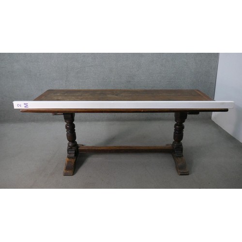 94 - A 19th century oak extending refectory dining table in the antique style, the plank top with cleated... 
