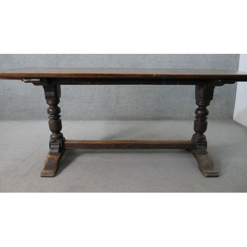 94 - A 19th century oak extending refectory dining table in the antique style, the plank top with cleated... 