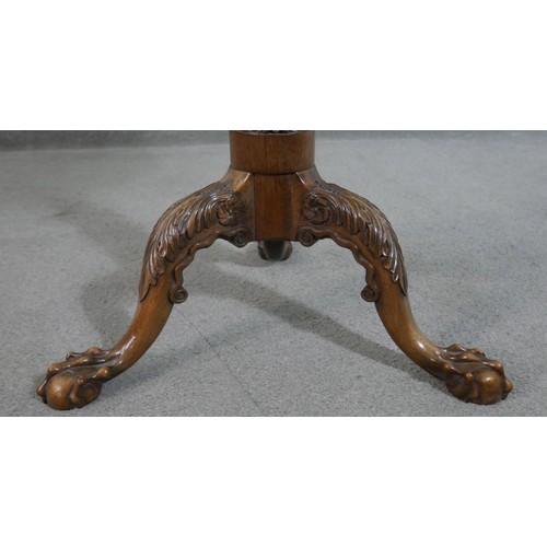 215 - A Victorian walnut tripod table, the hexagonal tilt top with an ornately carved and pierced edge, on... 