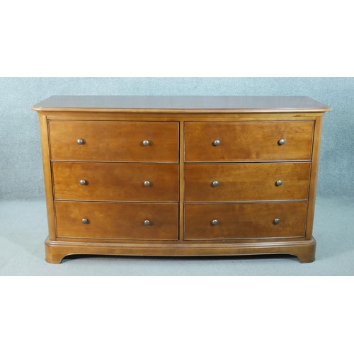 299 - A Victorian style fruitwood bow front chest, with two banks of three drawers with knob handles, on a... 