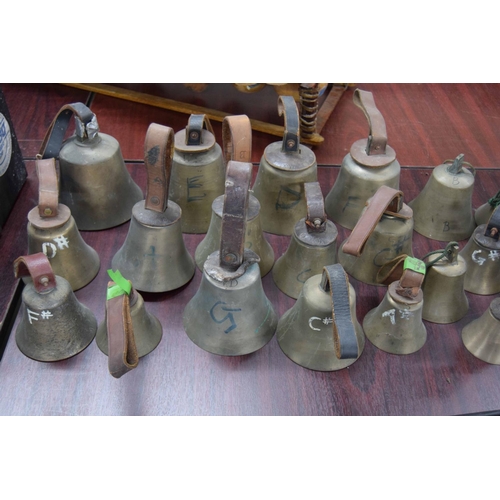 1321 - Twenty-four hand bells, some bearing original tooled leather handles inscribed with the initials 'WD... 