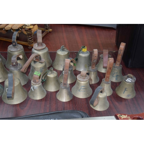 1321 - Twenty-four hand bells, some bearing original tooled leather handles inscribed with the initials 'WD... 