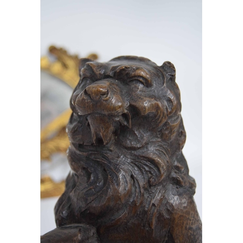 318 - 17th century carved oak lion, modelled holding a scrolling shield, 14