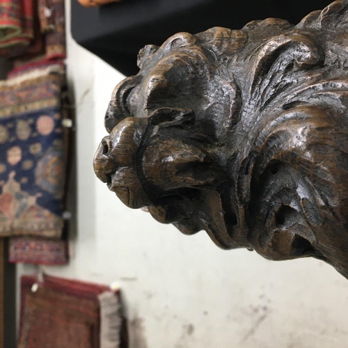 318 - 17th century carved oak lion, modelled holding a scrolling shield, 14