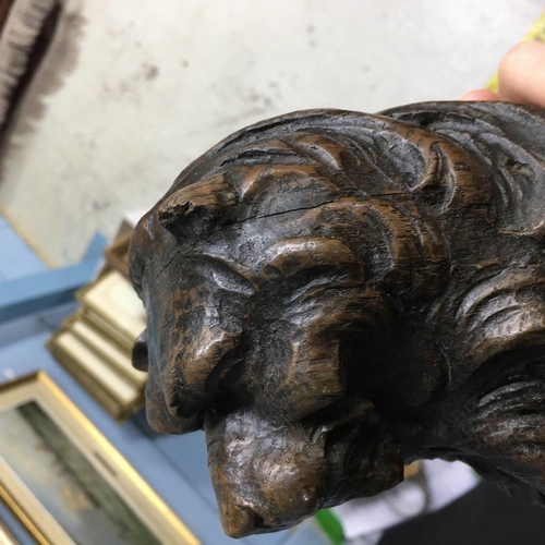 318 - 17th century carved oak lion, modelled holding a scrolling shield, 14