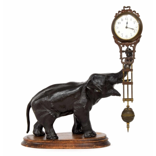 2506 - Novelty spelter elephant mystery clock, upon a shaped stepped wooden base, 11