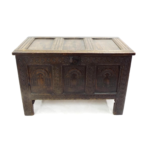 201 - Small 17th century oak coffer, with a triple panelled arcaded front within carved floral borders and... 