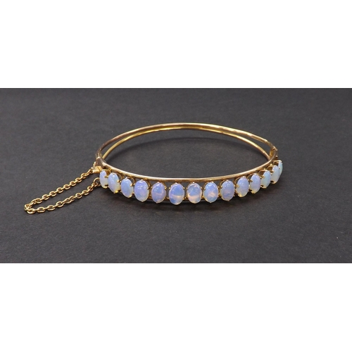 46 - Antique gold diamond set hinged bangle set with fourteen opal cabochons, with safety chain, 9.6gm, 6... 