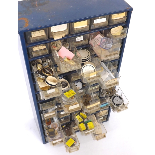 664 - Quantity of various watch parts contained within a sixty drawer storage unit to include bolt screws,... 