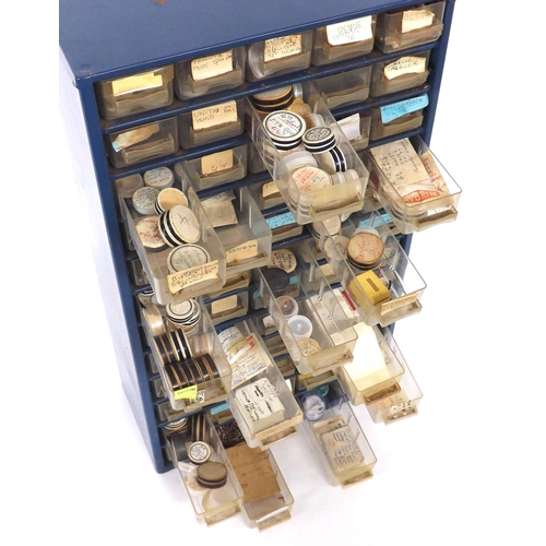 665 - Quantity of watch parts contained within a sixty drawer storage unit to include wheels, barrels, cli... 