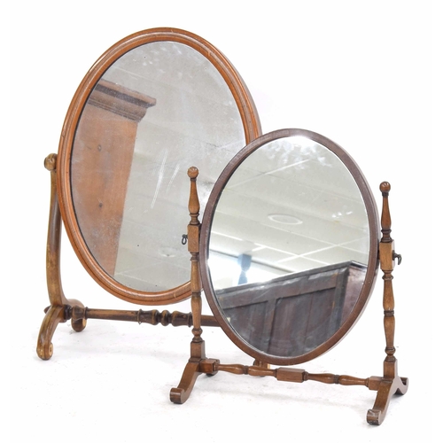 341 - Two oval swing/loo mirrors, the largest on scrolling supports, 28