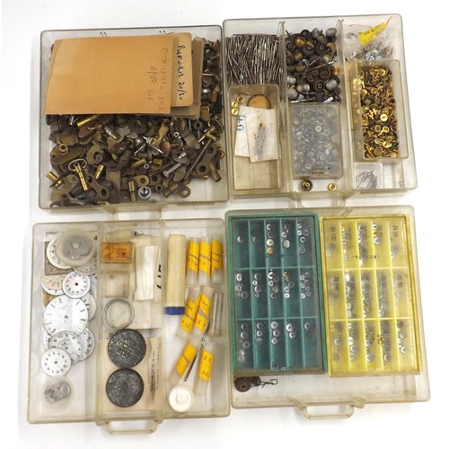 607 - Selection of watch parts contained within four chests to include dials, crowns, pocket watch buttons... 