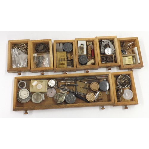 607 - Selection of watch parts contained within four chests to include dials, crowns, pocket watch buttons... 