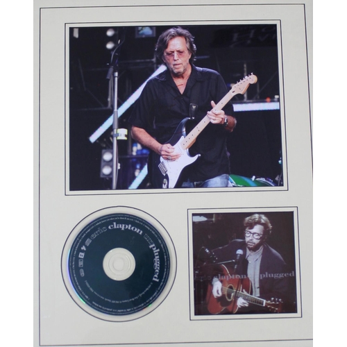 562 - Eric Clapton - autographed framed display, signed in red pen upon a photograph of Eric Clapton playi... 