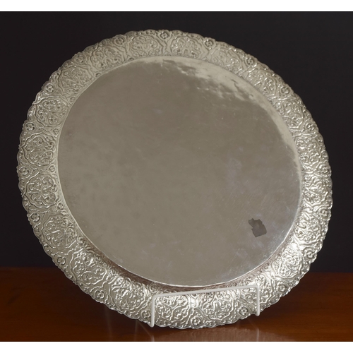 587 - Large Greek white metal (900) circular serving tray, with a stylised arabesque embossed wide rim, ma... 