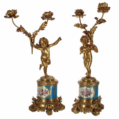 623 - Attractive pair of French porcelain and ormolu figural twin branch candelabra, modelled as putti fig... 