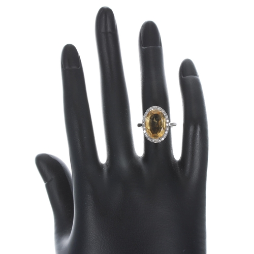 103 - Platinum citrine and diamond oval ring, the citrine 4.15ct approx, in a surround of round-cut diamon... 