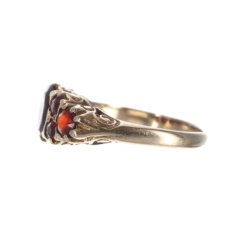 123 - Yellow gold scroll set garnet ring, width 8mm, 2.8gm, ring size L/M