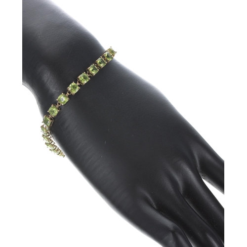 328 - 9ct peridot set line bracelet, set with twenty-five cushion-cut peridot, width 5mm, 7.2gm, 7.5