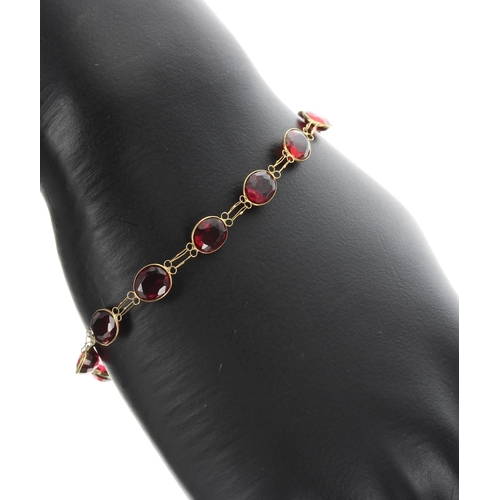 225 - 14k red garnet set bracelet, with twelve garnets in yellow gold, 4.3gm, 7